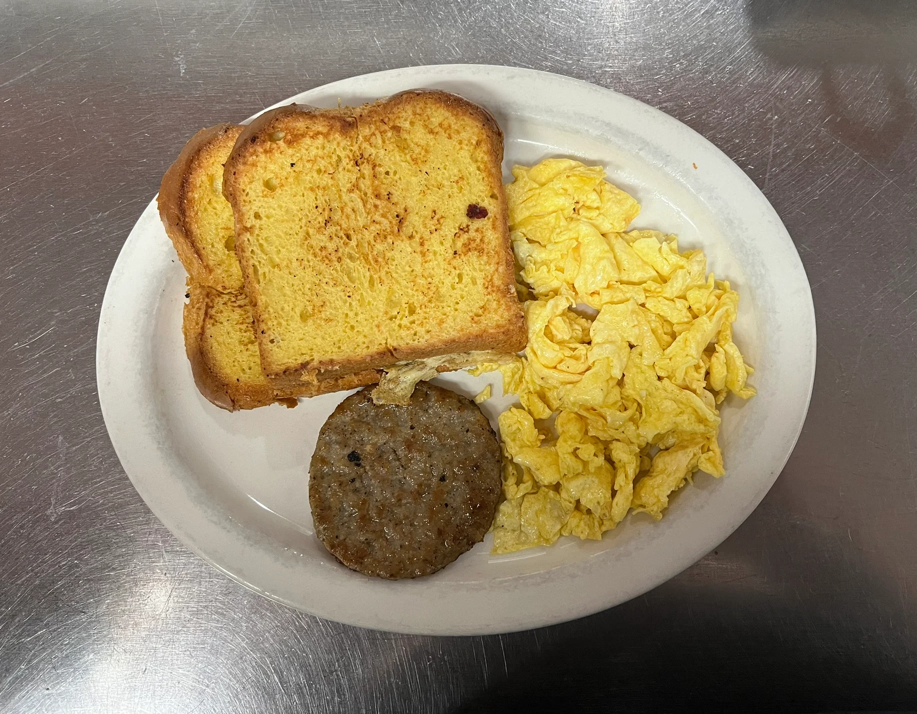 A plate of toasted bread slices, scrambled eggs, and pancake